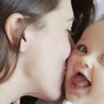portrait of cute baby girl being kissed by mother 2022 03 04 01 44 43 utc 900x370 1