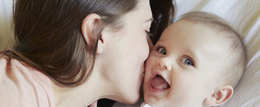 portrait of cute baby girl being kissed by mother 2022 03 04 01 44 43 utc 900x370 1